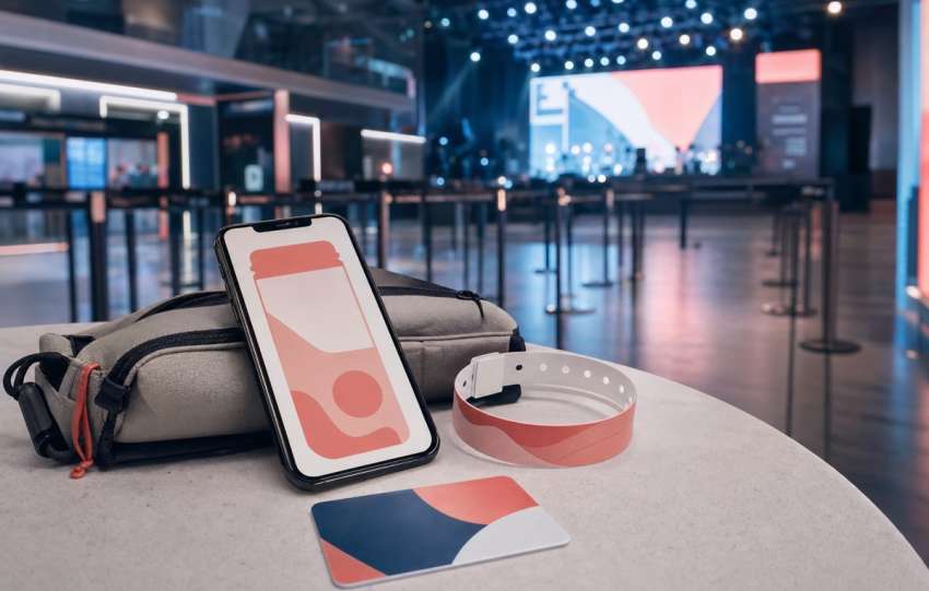 Abstract mobile ticket, wristband, and small bag at an event venue