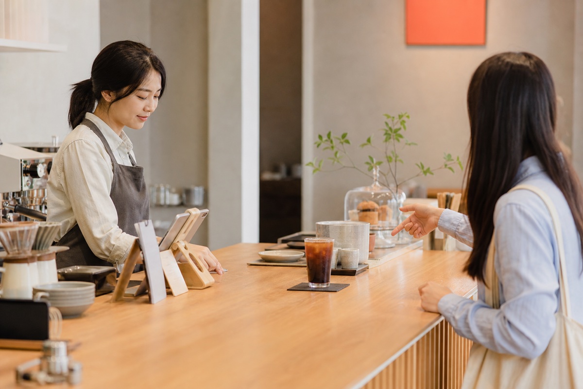 Customer ordering an iced drink at a bright unbranded cafe