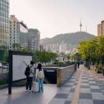 Travelers checking a map near a Seoul transit entrance