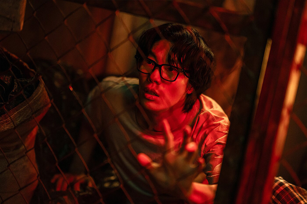 Moon-jae reaches through a barrier in an official Mousetrap production still